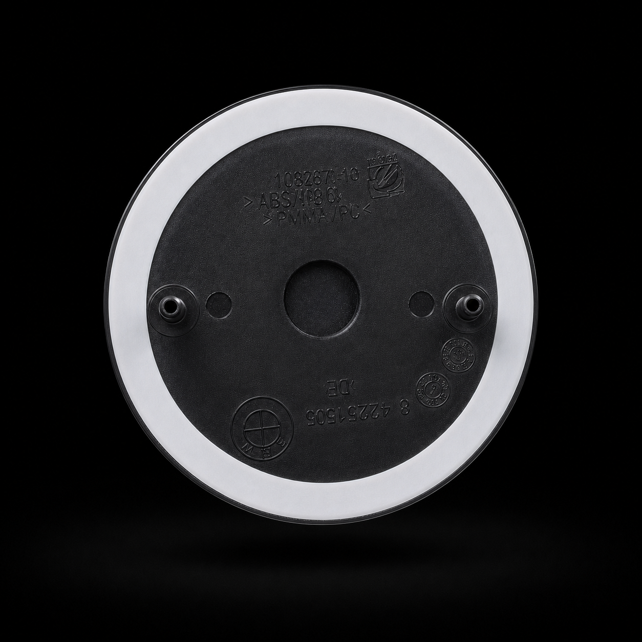 Badge rear view — two mounting pins and double-sided automotive tape ring, no drilling