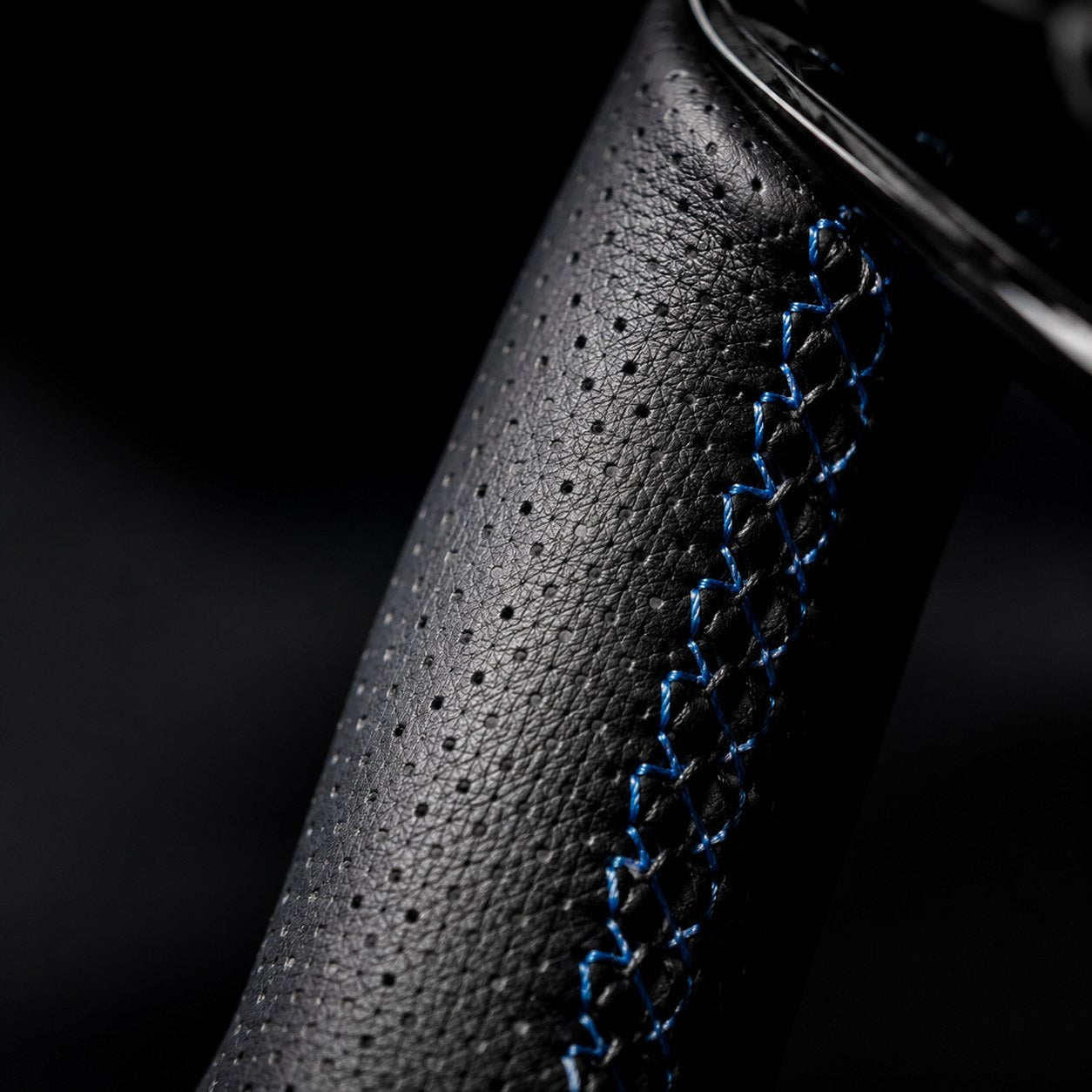 Perforated leather grip and contrast stitching detail